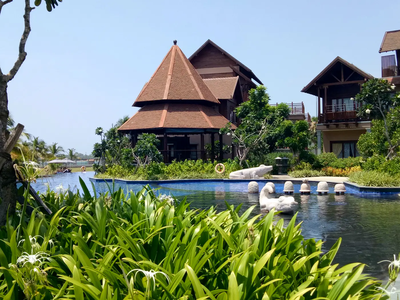 Broad manicured resort lawn bordered by tropical planting
